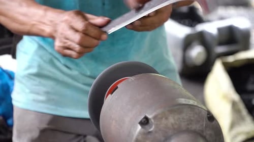 Metal Worker Sharpening Metal Blade