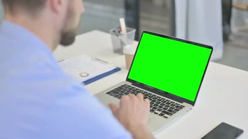 Adult Typing on Laptop with Green Screen