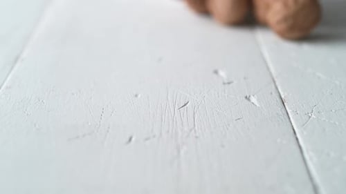 Camera follows walnuts in shell rolling on the table. Slow Motion.