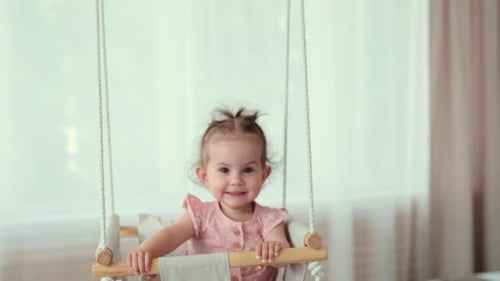 Adorable Child on a Swing Smiling Happily