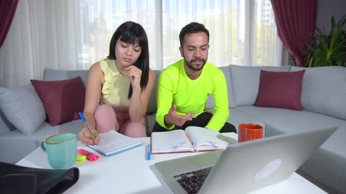 Young Adults Studying Together at Home with Laptop