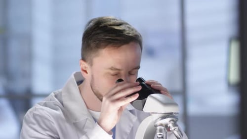 Scientist Working with Microscope in Bright Laboratory