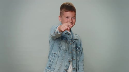 Kleinkind Junge zeigt auf die Kamera und schaut mit verspieltem, fröhlichem Ausdruck und trifft Wahl Hey you