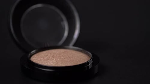 Close Up of Brush and Face Powder Isolated on Black