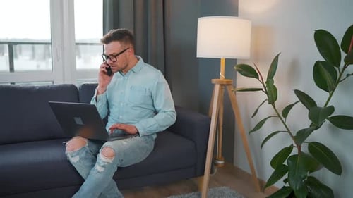 Man Working From Home On Laptop And Phone
