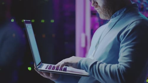 Server Administrator Using Laptop at Work in Data Center