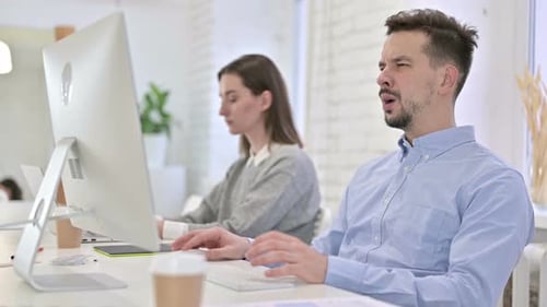 Frustrated Man Reacts to Computer Problem at Workplace