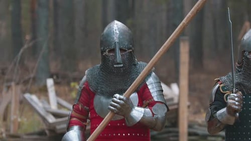 A Man Knight Walking in the Forest in Full Armour Holding a Weapon