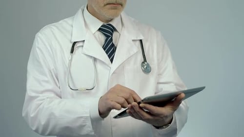 Therapist Using Tablet PC to Check Patient's Medical Record or Lab Test Results