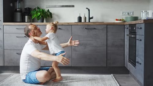 Father and Daughter Embrace in Kitchen