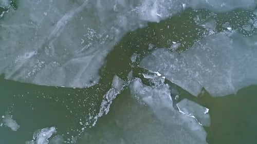 Rising aerial view of ice sheets on frozen lake viewing different patterns