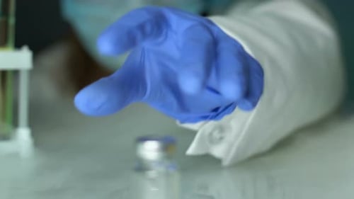 Expert de laboratoire prélevant un échantillon de vaccin, vérifiant la qualité du médicament, pharmacie