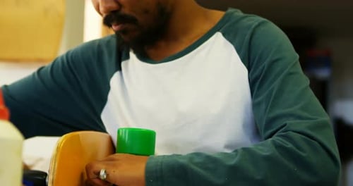 Man Working on Skateboard in Workshop