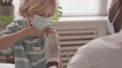 Young Boy Receiving Vaccination from Doctor in Clinic