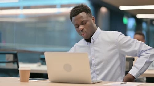 Young Adult with Back Pain at Computer
