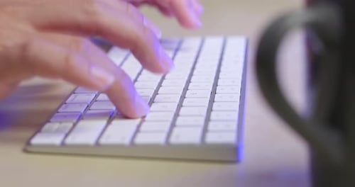 Man typing on keyboard at home