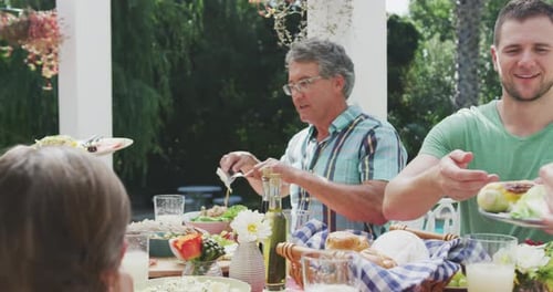 Family Enjoying Outdoor Meal Together in Sunny Garden