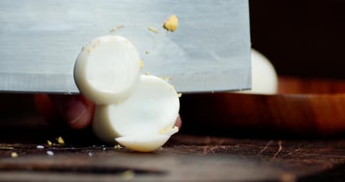 Slicing a Boiled Egg on Wooden Cutting Board