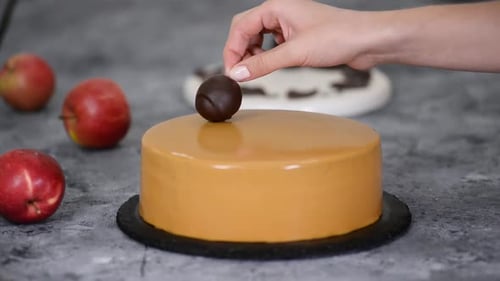 Pastry Chef Decorating the Cake with Chocolate Apples and Leaves. Pastry Chef Decorated Modern