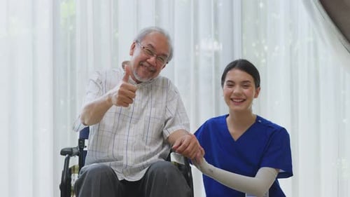 Smiling Senior Man with Healthcare Worker Gives Thumbs Up