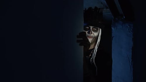 Creepy Man with Halloween Skeleton Makeup Slowly Appears From Dark Corner with Frightening Smile