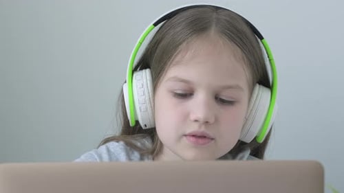 Caucasian School Girl Pupil Video Call Online Via Internet Tutor on Computer Laptop with Headphones