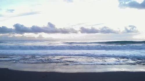 White foamy waves breaking on seashore. Powerful ocean waves crashing on beach and splashing.
