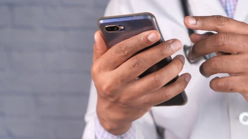Doctor Uses Smartphone in Medical Clinic