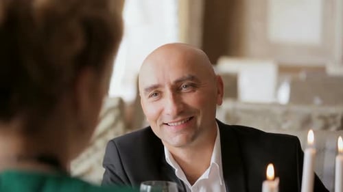 Romantic Couple Dining by Candlelight in Restaurant