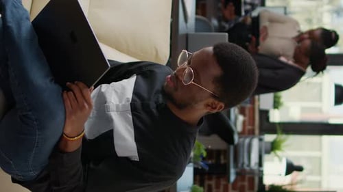 Young Adult Smiling with Laptop in Office