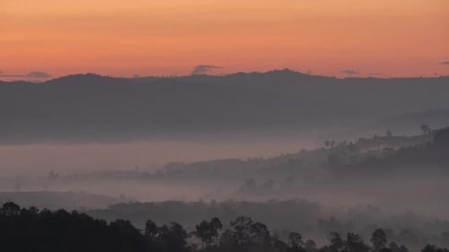 Misty Mountains at Sunrise With Orange Sky