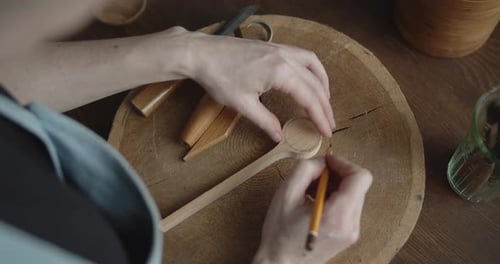 Woman Carpenter Drawing Markup with a Pencil on a Piece of Wood Close-up
