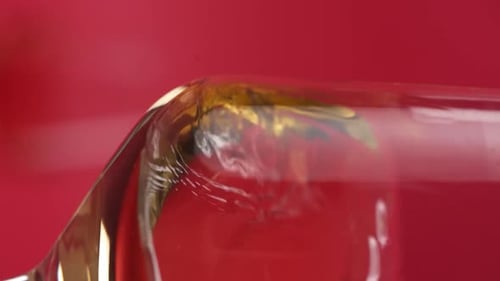 Vertikales Video, Nahaufnahme: Rotwein wird in ein Glas gegossen