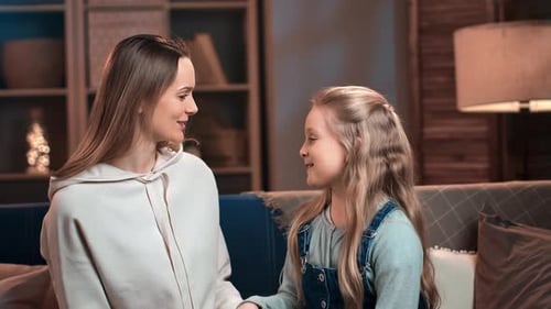 Woman and Child Smiling and Conversing on Couch