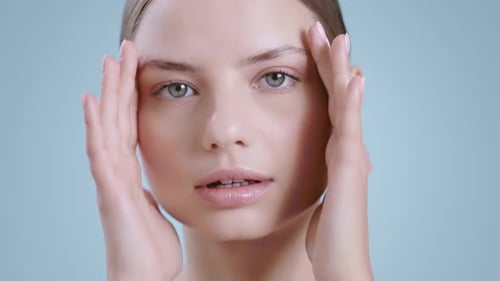 Close Up of Pretty Woman Massaging Face with Hands While Looking to Camera
