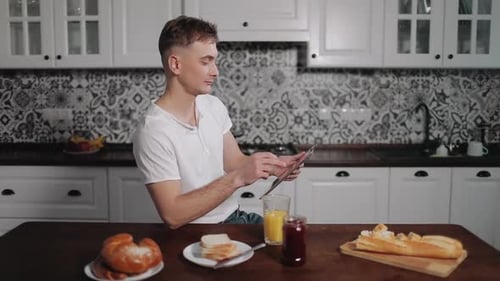 Man Using Tablet and Drinking Juice