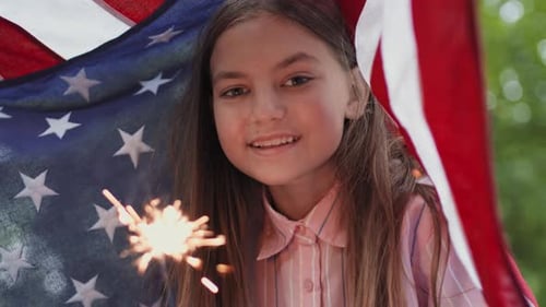 Girl Holding Sparkler Draped in American Flag