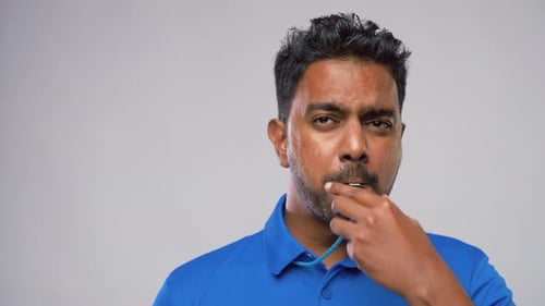 Un arbitre indien siffle et montre un carton jaune