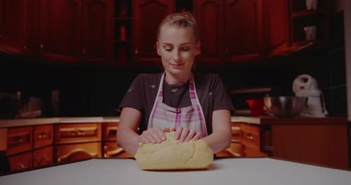 Woman Kneading Dough in a Warm Kitchen