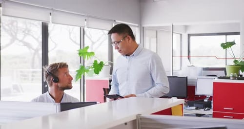 Senior Geschäftsmann spricht in Zeitlupe mit jungen Geschäftsleuten im modernen Büro