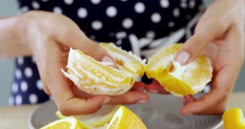 Woman peeling orange