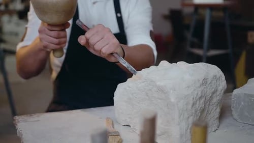 Male Hands which Holding the Mallet ans Chisel Knocking off the Shape of Future Sculpture