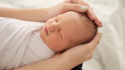Sleeping Newborn Safe in Gentle Hands