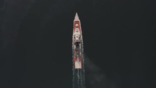 Drone View of a Modern Corvetteclass Ship Going Out to Sea Under the Bridge
