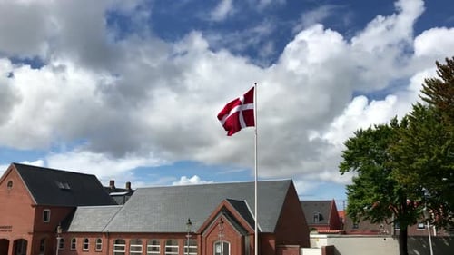 La
bandera de Dinamarca se balancea con el viento en el gran poste. Tomada en Esbjerg, Dinamarca.