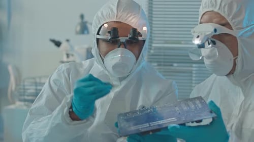 Technicians Inspecting Circuit Board in Lab