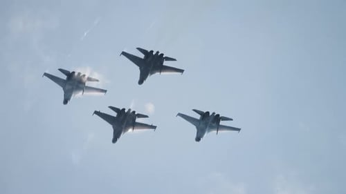 Jets Fly in Formation Against Cloudy Sky