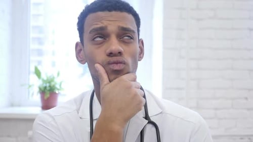 Pensive Doctor Thinks with Hand on Face