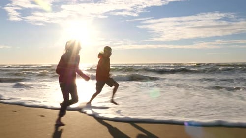 Two children running at beach