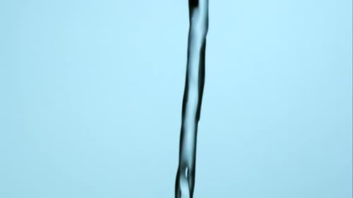 Macro Shot of Flowing Water on Blue Background